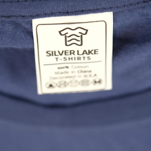 May include: White tag with black text that reads "Silver Lake T-Shirts". The tag also includes a graphic of a t-shirt with wavy lines. The tag also includes care instructions.