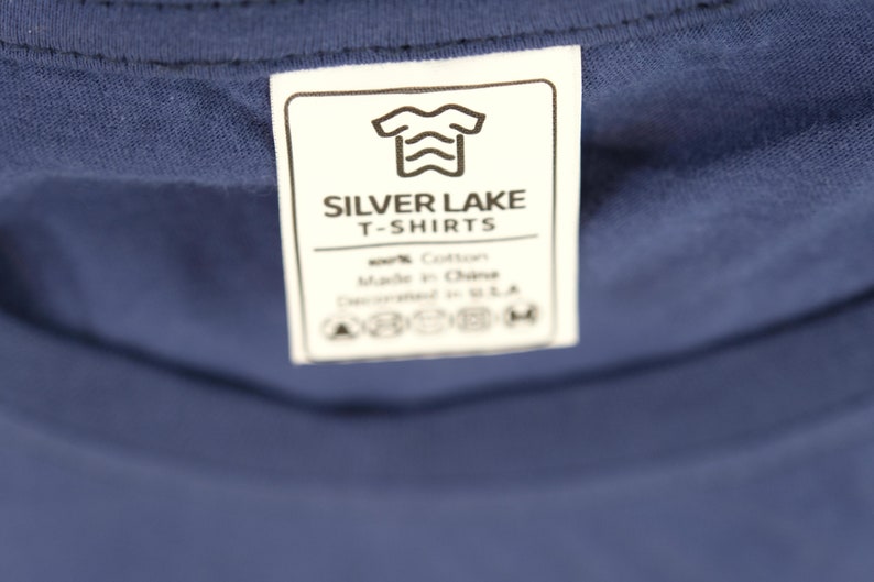 May include: White tag with black text that reads "Silver Lake T-Shirts". The tag also includes a graphic of a t-shirt with wavy lines. The tag also includes care instructions.