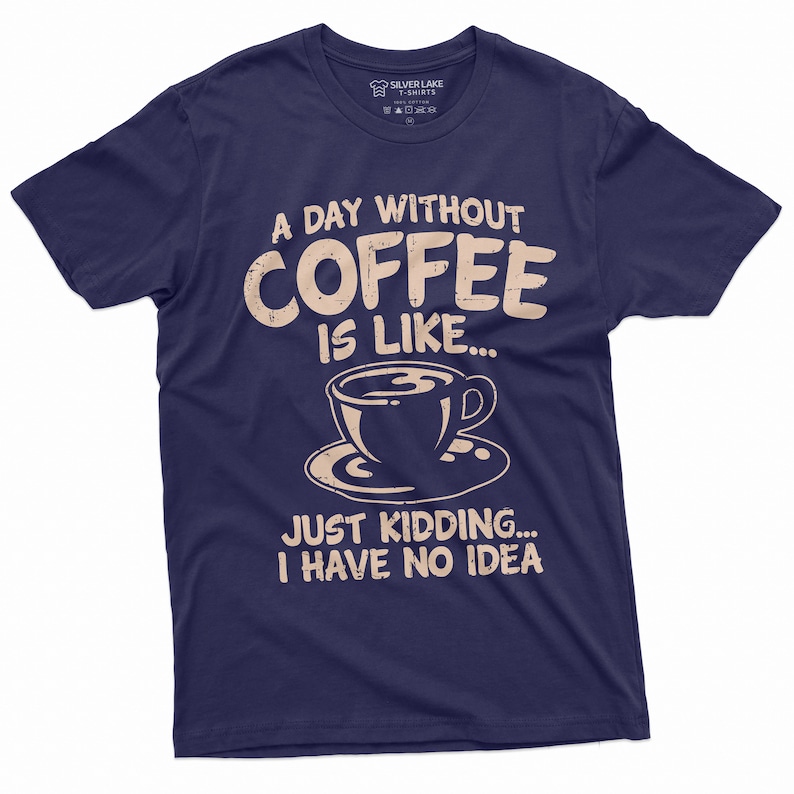 May include: A navy blue t-shirt with a distressed white graphic that reads "A day without coffee is like... Just kidding... I have no idea". The graphic also includes a stylized image of a coffee cup.