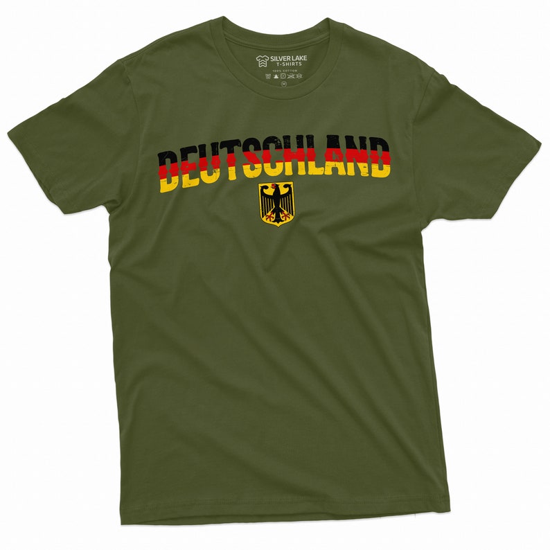May include: A green t-shirt with the word "DEUTSCHLAND" printed in black, red, and yellow letters. The German flag colors are incorporated into the letters. A yellow and black German eagle is printed below the word.