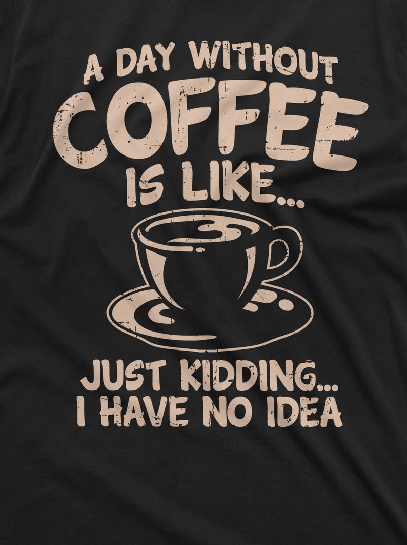 May include: A black t-shirt with a distressed white graphic that reads "A day without coffee is like..." and features a coffee cup and saucer. The text continues with "Just kidding... I have no idea."