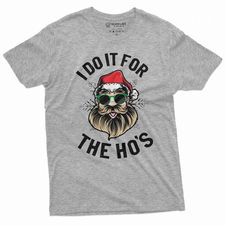 May include: Gray t-shirt with a graphic of Santa Claus wearing sunglasses and a beard. The text "I do it for the ho's" is printed on the shirt.