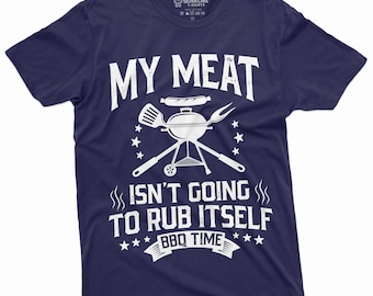 May include: A navy blue t-shirt with a white graphic of a grill, spatula, fork, and sausage. The text on the shirt reads "My Meat Isn't Going To Rub Itself BBQ Time".