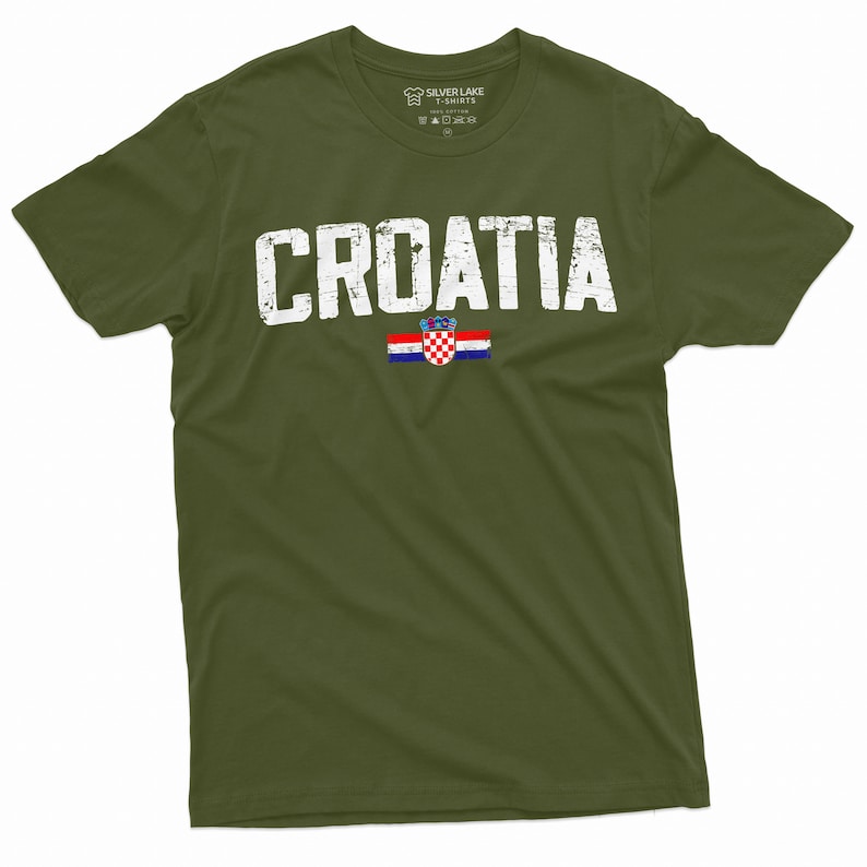 以下が含まれることがあります： 緑色のTシャツに、くたびれた感じの白い文字で「CROATIA」とプリントされています。その下にクロアチアの旗がプリントされています。