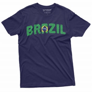 Puede incluir: Una camiseta azul marino con un gr&aacute;fico desgastado en verde y amarillo de la palabra "BRAZIL" con la bandera brasile&ntilde;a incorporada en la "A".