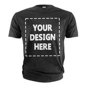 Op de afbeelding: Zwart T-shirt met de witte tekst "YOUR DESIGN HERE" in een wit gestippeld vierkant. Het T-shirt heeft een ronde hals en lijkt gemaakt van een zacht materiaal.