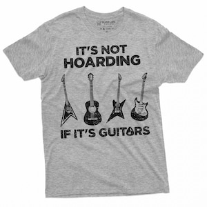 May include: Gray t-shirt with a black graphic print that says "It's not hoarding if it's guitars". The graphic features five different guitars in black and white.
