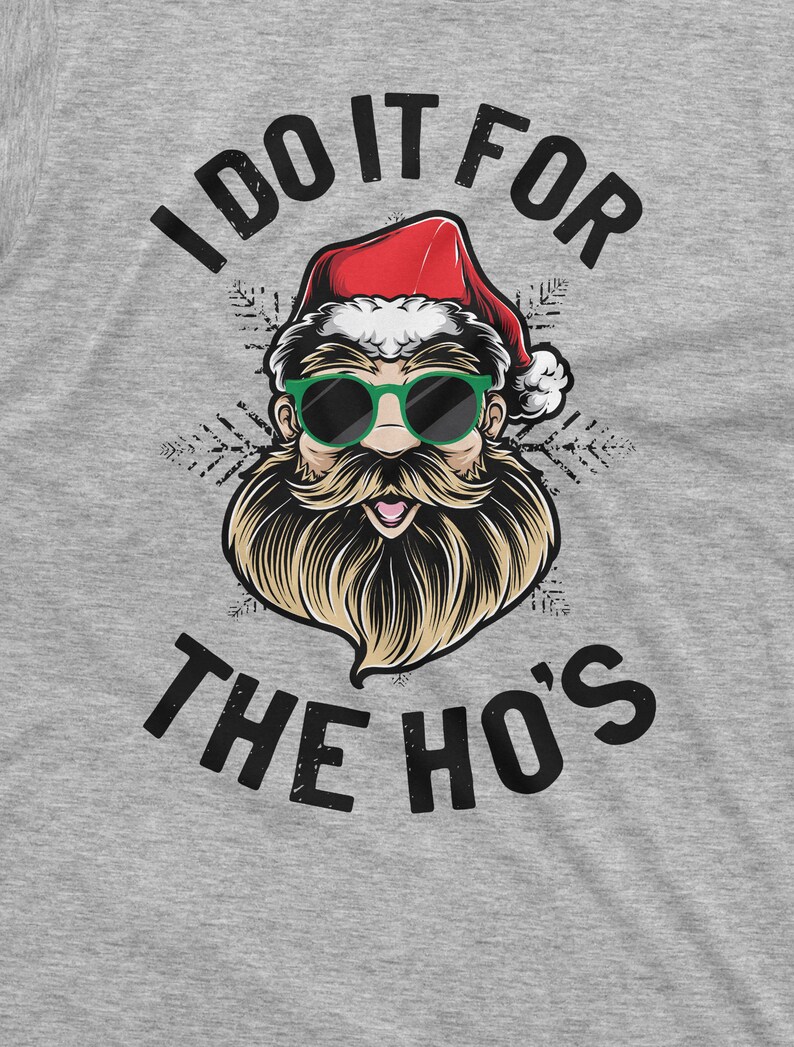 May include: A gray t-shirt with a graphic of Santa Claus wearing sunglasses and a beard. The text "I do it for the ho's" is printed on the shirt.