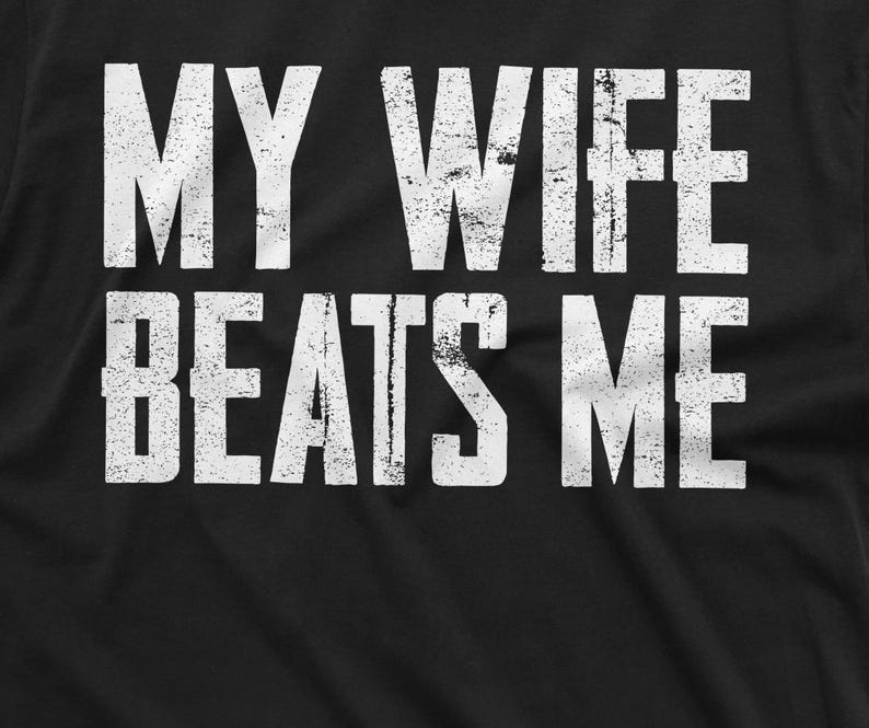 May include: Black t-shirt with white text that reads "My wife beats me".