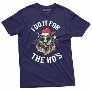 May include: A navy blue t-shirt with a white graphic of Santa Claus wearing sunglasses and a beard. The text "I do it for the ho's" is printed in white below the graphic.