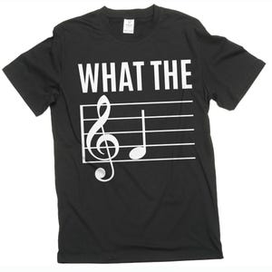 May include: Black t-shirt with the text "WHAT THE" printed in white, along with a treble clef and a quarter note on a musical staff.