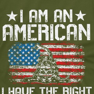 Puede incluir: Una camiseta verde con un gr&aacute;fico blanco desgastado de una bandera estadounidense con una serpiente y el texto "I am an American I have the right to bear arms".