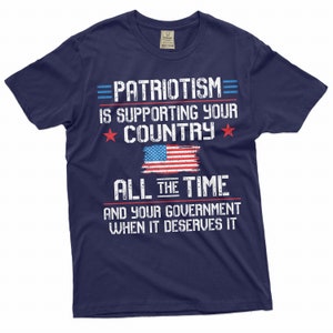 May include: Navy blue t-shirt with a distressed white graphic that reads "PATRIOTISM IS SUPPORTING YOUR COUNTRY ALL THE TIME AND YOUR GOVERNMENT WHEN IT DESERVES IT". The graphic also includes a red, white, and blue American flag.