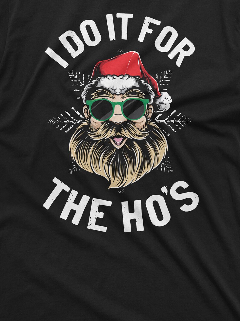 May include: A black t-shirt with a white graphic of Santa Claus wearing sunglasses and a beard. The text "I do it for the ho's" is printed in white below the graphic.