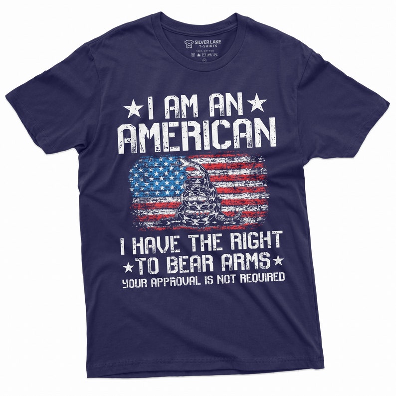 Puede incluir: Camiseta azul marino con un dise&ntilde;o de bandera estadounidense desgastado y el texto "Soy un estadounidense. Tengo derecho a portar armas. Tu aprobaci&oacute;n no es necesaria."