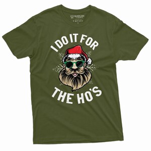 May include: Green t-shirt with a white graphic of Santa Claus wearing sunglasses and a beard. The text "I do it for the ho's" is printed below the image.