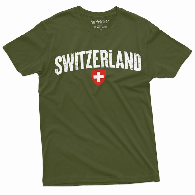 May include: A green t-shirt with the word "SWITZERLAND" printed in white with a distressed look. The Swiss flag is printed in red and white below the word.