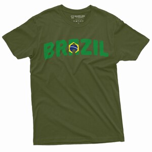 Puede incluir: Una camiseta verde con la palabra "BRASIL" impresa en letras verdes con un efecto descolorido. La letra "I" est&aacute; reemplazada por la bandera brasile&ntilde;a.