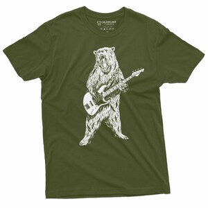 K&ouml;nnte beinhalten: Ein gr&uuml;nes T-Shirt mit einer wei&szlig;en Illustration eines B&auml;ren, der Bass spielt. Der B&auml;r steht auf seinen Hinterbeinen und hat einen br&uuml;llenden Ausdruck. Das T-Shirt hat ein Etikett am Hals, auf dem "Silver Lake T-Shirts" steht.