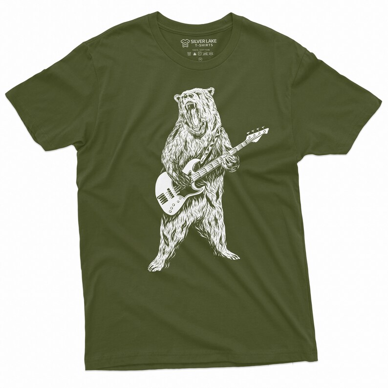 K&ouml;nnte beinhalten: Ein gr&uuml;nes T-Shirt mit einer wei&szlig;en Illustration eines B&auml;ren, der Bass spielt. Der B&auml;r steht auf seinen Hinterbeinen und hat einen br&uuml;llenden Ausdruck. Das T-Shirt hat ein Etikett am Hals, auf dem "Silver Lake T-Shirts" steht.