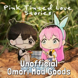 May include: A pair of acrylic character standees featuring a pink-haired girl with a blue bow and a boy with brown hair and an eyepatch. The standees are set against a green leafy background and have the text "Pink Tinted Love Stories" and "Unofficial Omori Mod Goods" printed on them.