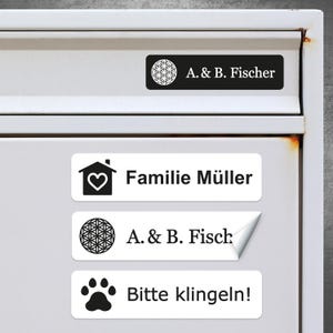 Könnte beinhalten: Drei weiße rechteckige Etiketten mit schwarzem Text und Symbolen. Das obere Etikett lautet "A & B. Fischer" mit einem geometrischen Symbol. Das mittlere Etikett lautet "Familie Müller" mit einem Haussymbol. Das untere Etikett lautet "A & B. Fisch" mit einem geometrischen Symbol und "Bitte klingeln!" mit einem Pfotenabdruck.