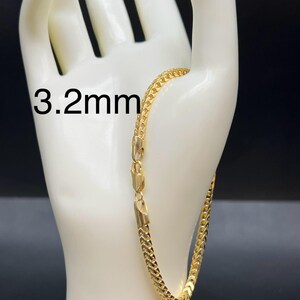 May include: A gold chain bracelet with a 3.2mm width. The bracelet is on a white mannequin hand.