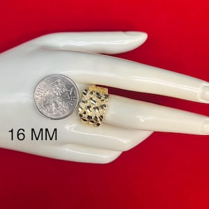 May include: A gold ring with a textured surface. The ring is 16 mm wide. The ring is displayed on a hand model.