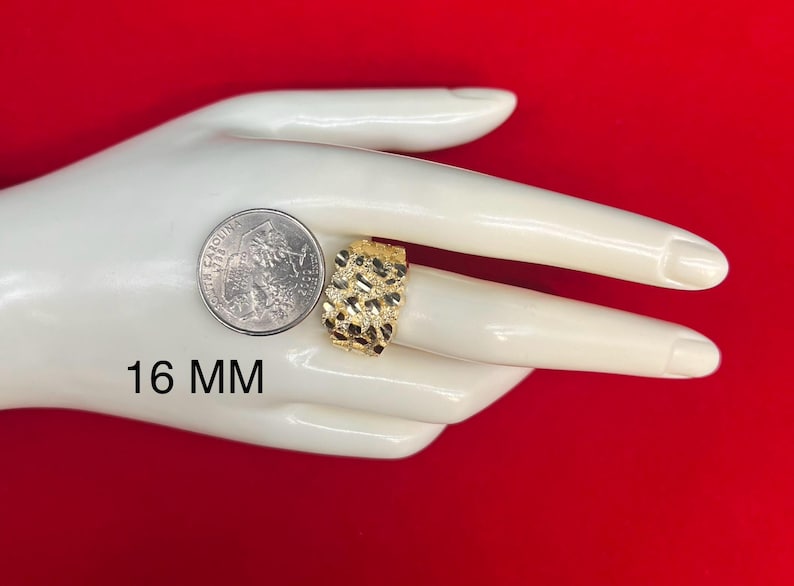 May include: A gold ring with a textured surface. The ring is 16 mm wide. The ring is displayed on a hand model.