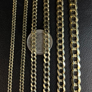 May include: Four gold chains of different widths and lengths, laid out side-by-side on a black surface. A US quarter is placed next to the chains for size comparison.
