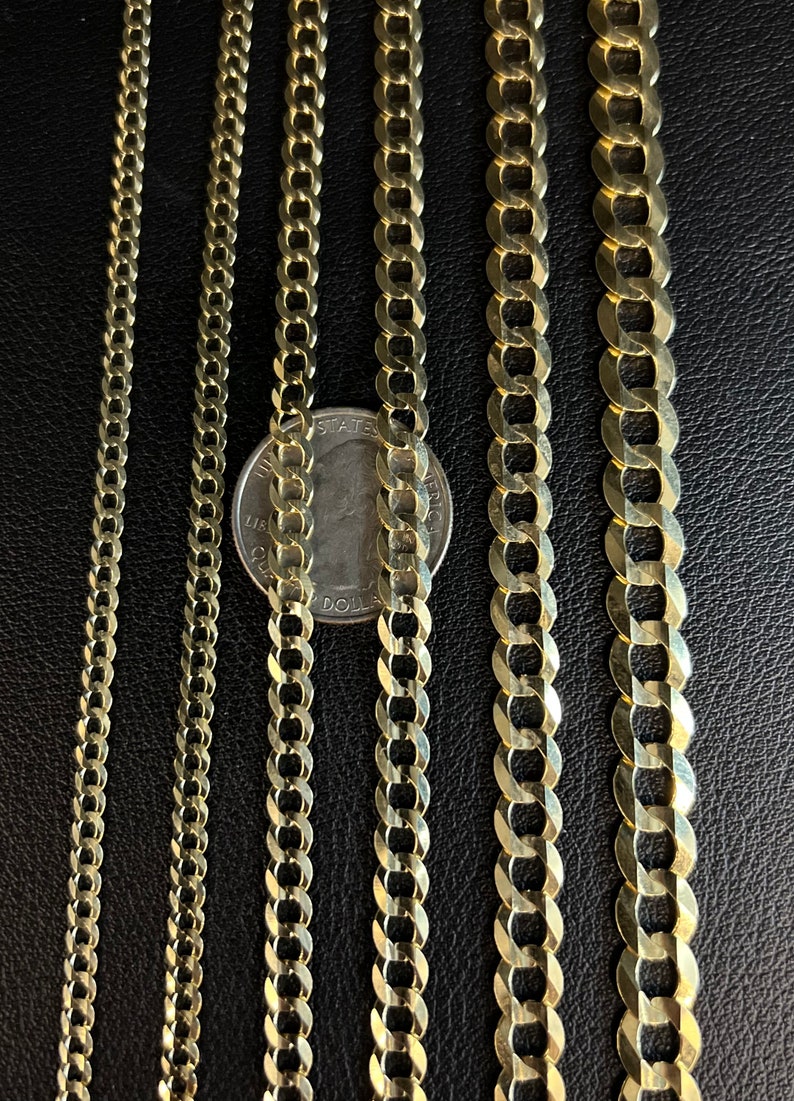 May include: Four gold chains of different widths and lengths, laid out side-by-side on a black surface. A US quarter is placed next to the chains for size comparison.