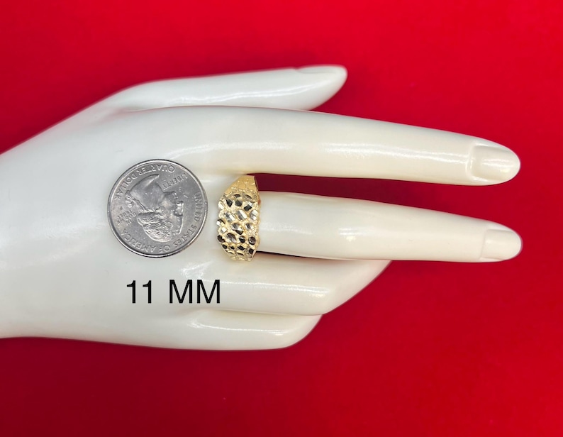 May include: A gold signet ring with a textured surface. The ring is 11 mm wide.