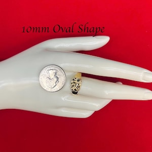 May include: A gold ring with a 10mm oval-shaped stone. The ring is on a hand, and a US quarter is shown for size comparison. 10mm Oval Shape.