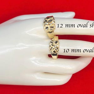 May include: Two gold rings with a textured surface. The ring on the left is 12 mm oval shape and the ring on the right is 10 mm oval shape.