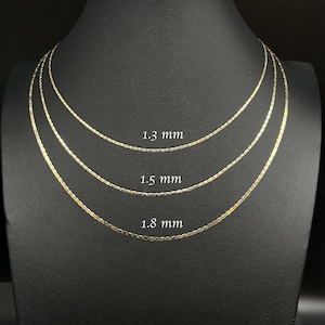 May include: Three gold chains of different widths, 1.3 mm, 1.5 mm, and 1.8 mm, displayed on a black mannequin.