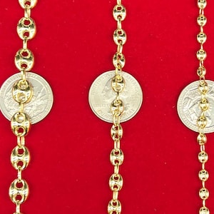 K&ouml;nnte beinhalten: Drei goldene Ketten mit ovalen Gliedern, jede Kette liegt neben einem US-Viertel, um die Gr&ouml;&szlig;e der Kette zu zeigen.