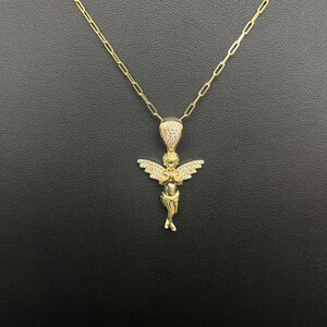 Puede incluir: Collar de cadena de oro con un peque&ntilde;o colgante de &aacute;ngel detallado incrustado con piedras de circonita c&uacute;bica transparentes.