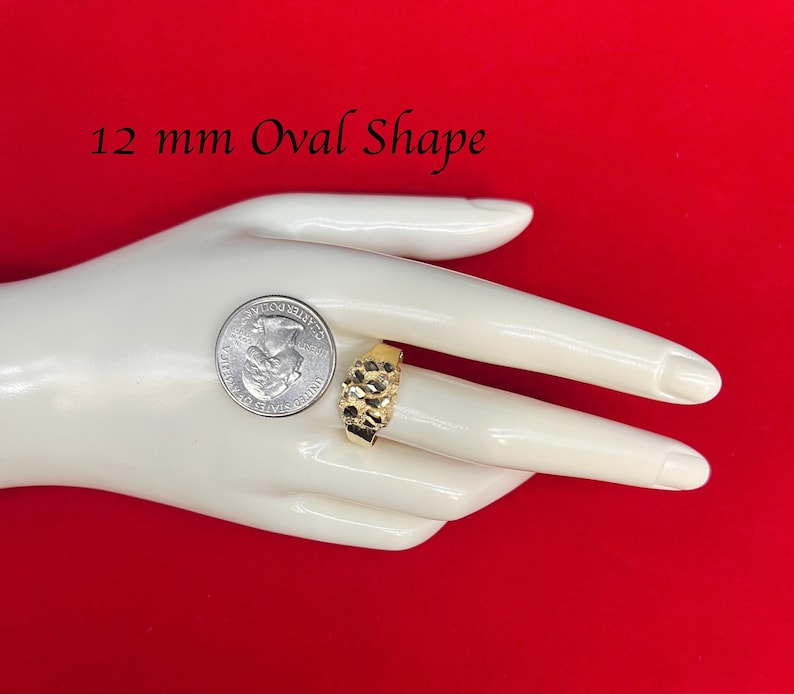 May include: A gold ring with a textured oval shape. The ring is 12 mm in size and is shown on a mannequin hand.