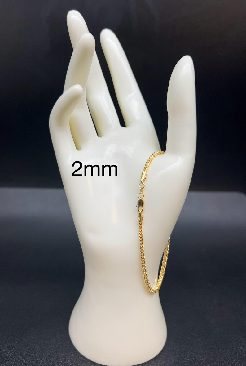 May include: A gold chain bracelet with a lobster clasp. The chain is 2mm wide.