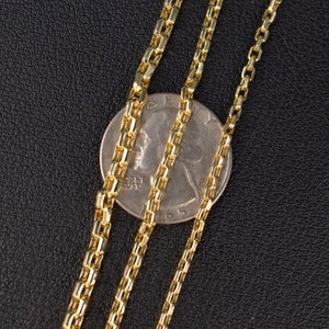 May include: Three gold chains of different lengths, laid out on a black surface. A silver US quarter is placed under the chains for size comparison.