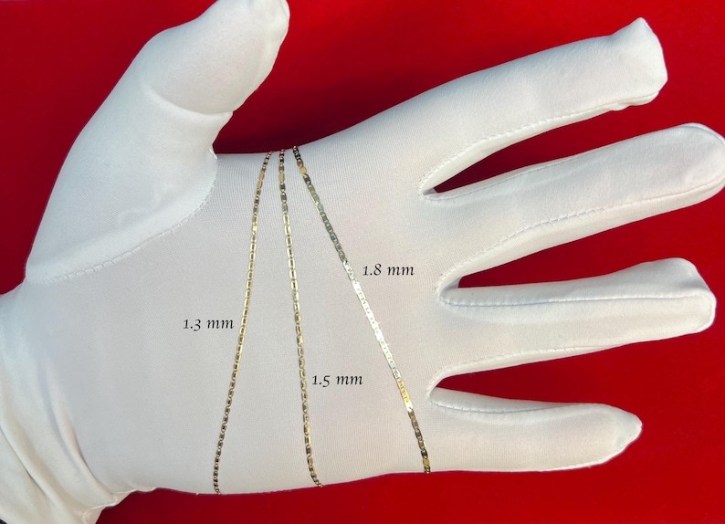May include: Three gold chains of different widths laid out on a white surface. The chains are labeled with their widths in millimeters: 1.3 mm, 1.5 mm, and 1.8 mm.