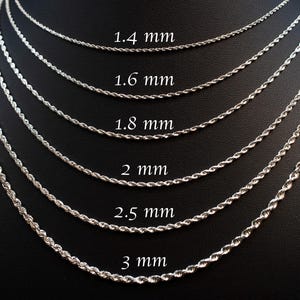 May include: Silver-colored rope chain necklaces in various thicknesses, from 1.4 mm to 3 mm, displayed on a black background. The sizes are labeled in millimeters. The chains are tightly twisted, reflecting light.