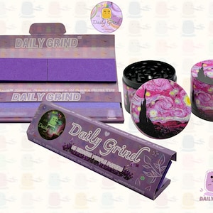 A dark Purple packet and a Green box with the text 'Daily Grind' on both and ‘Kingsize Purple Papers' on one and ‘Kingsize Green Papers’ on the other. Both boxes open showing green papers in one and purple in the other. There is a tobacco grinder with a classic pink piece of art underneath it and The 'Daily Grind' logo is in the corner of the image