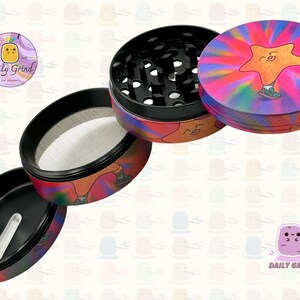 A four piece Metal Tobacco Grinder with a colourful striking design disassembled and showing all the different layers, the top two contain the grinding teeth and the bottom two are for storage. The grinder features a star very happy in the middle of the image with a multi coloured explosion behind him. The inside of the grinder is black. The Daily Grind logo is visible in the corner of the image