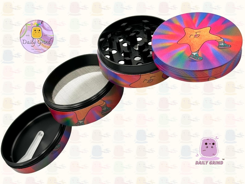 A four piece Metal Tobacco Grinder with a colourful striking design disassembled and showing all the different layers, the top two contain the grinding teeth and the bottom two are for storage. The grinder features a star very happy in the middle of the image with a multi coloured explosion behind him. The inside of the grinder is black. The Daily Grind logo is visible in the corner of the image