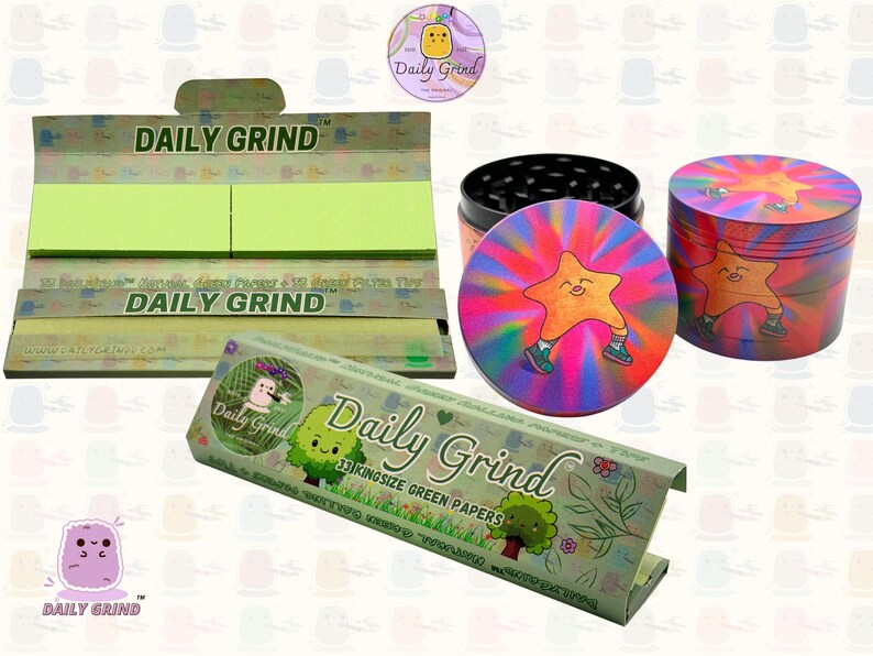 A dark Purple packet and a Green box with the text 'Daily Grind' on both and ‘Kingsize Purple Papers' on one and ‘Kingsize Green Papers’ on the other. Both boxes open showing green papers in one and purple in the other. There is a tobacco grinder with a very happy and confident star character in the middle with rays of light behind him underneath it and The 'Daily Grind' logo is in the corner of the image