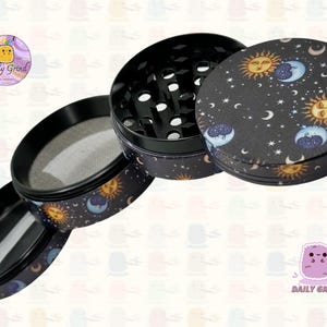 A four piece Metal Tobacco Grinder with a spiritual astrology design disassembled and showing all the different layers, the top two contain the grinding teeth and the bottom two are for storage. The grinder features a cartoon sun & moon in a dark night sky full of stars . The inside of the grinder is black. The Daily Grind logo is visible in the corner of the image