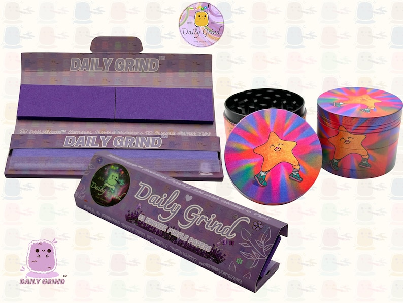 A dark Purple packet and a Green box with the text 'Daily Grind' on both and ‘Kingsize Purple Papers' on one and ‘Kingsize Green Papers’ on the other. Both boxes open showing green papers in one and purple in the other. There is a tobacco grinder with a very happy and confident star character in the middle with rays of light behind him underneath it and The 'Daily Grind' logo is in the corner of the image