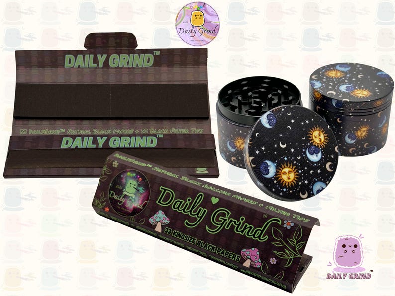 A black and green box with the text 'Daily Grind' and Kingsize Black Papers' on it. The box is open and there are black papers inside. There is a tobacco grinder with a cartoon sun and moon astrology design on it next to the box and the 'Daily Grind' logo is in the corner of the image