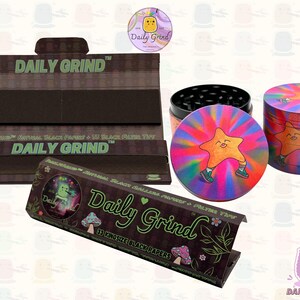 A black and green box with the text 'Daily Grind' and Kingsize Black Papers' on it. The box is open and there are black papers inside. There is a tobacco grinder with a very happy and confident star character in the middle with rays of light behind him next to the box and the 'Daily Grind' logo is in the corner of the image
